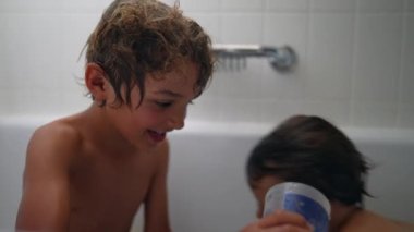 Çocukları içeride yıkıyorlar. Küçük kardeşle banyo yapan genç bir çocuk.