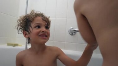 Çocukları içeride yıkıyorlar. Küçük kardeşle banyo yapan genç bir çocuk.
