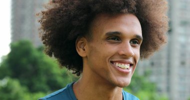 Handsome young black african man taking a deep breath and smiling