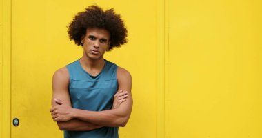 Upset angry african american black man crossing arms looking to camera with yellow background