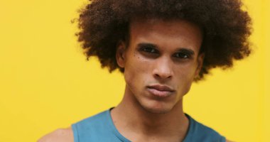 Upset angry young mixed race african american black man with yellow background