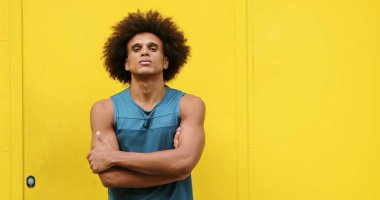 Upset angry african american black man crossing arms looking to camera with yellow background