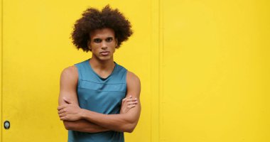 Upset angry african american black man crossing arms looking to camera with yellow background