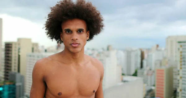 Shirtless young handsome mixed race african man standing on top of rooftop
