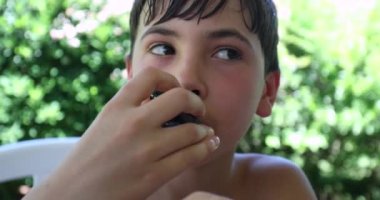 Dışarıda midye yiyen genç bir çocuk. Çocuk öğle yemeği yiyor