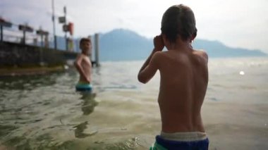 Çocuklar gölde yıkanıyor. İki çocuk yaz tatilinin tadını çıkarıyor.
