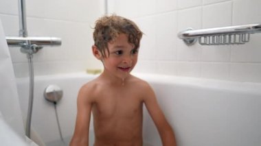 Çocuklar banyo yaparken su sıçratıyor. Banyo yapan iki küçük çocuk su sıçratıyor.