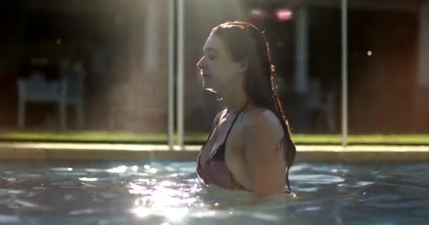 Vrouw Draait Haar Haar Sprays Zwembad Water Achter Haar — Stockvideo