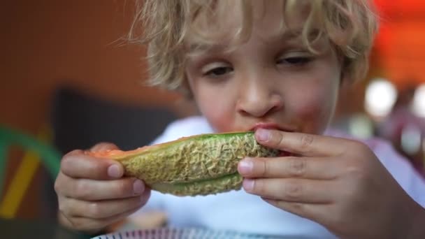 空腹の子供の果物を食べると 子供メロンを食べる 小さな男の子は健康的な果物を食べる — ストック動画