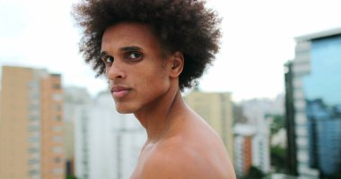 Young handsome african american man posing to camera with stoic expression