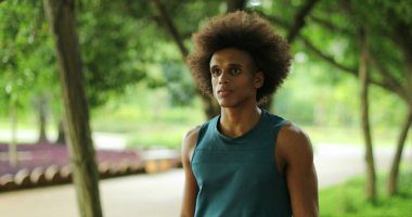Young black handsome african man walking at park pathway