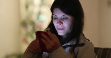 Gece akıllı telefon kullanan bir kadın, ekrana bakan bir kadın.