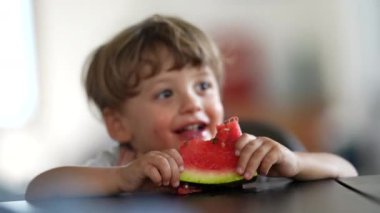 Küçük çocuk karpuz meyvesi yiyor. Çocuk sağlıklı meyve tatlısı yiyor.