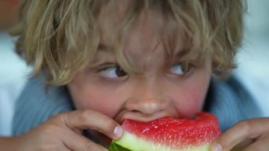 Küçük çocuk karpuz meyvesi yiyor. Çocuk sağlıklı meyve tatlısı yiyor.