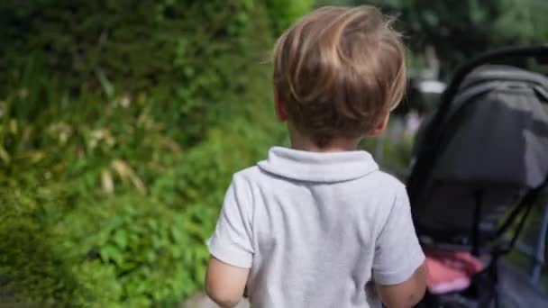 Маленький Хлопчик Ходить Матір Надворі Коляскою — стокове відео