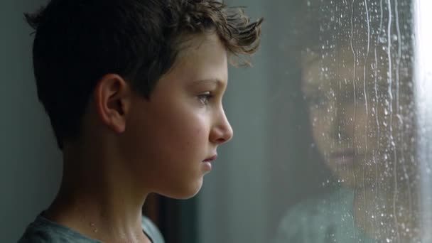 Pensief Kind Kijkt Uit Het Raam Tijdens Regenachtige Dag Bedachtzame — Stockvideo