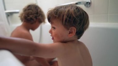 İki küçük kardeş birlikte banyo yapıyor.