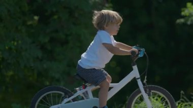 Parkta bisiklete binen bir çocuk.