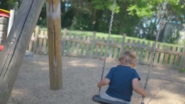 Çocuk oyun alanından düşüyor. Salıncak çocuk düşüyor.