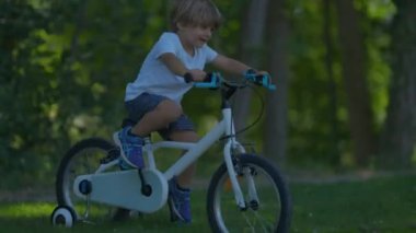 Aktif bir çocuk tepeden aşağı bisiklet sürüyor.