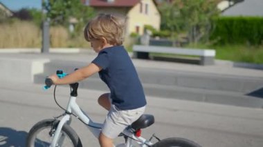Bisiklet süren aktif küçük bir çocuk Çocuk bisikleti sürüyor