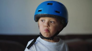 Koruyucu kask takan düşünceli küçük bir çocuk.