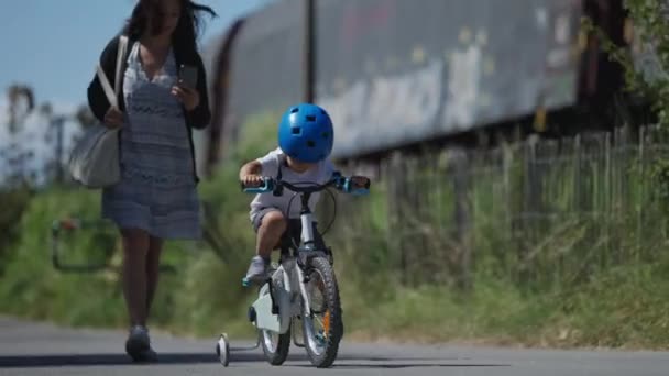 外面骑自行车的小男孩戴着头盔骑自行车 — 图库视频影像