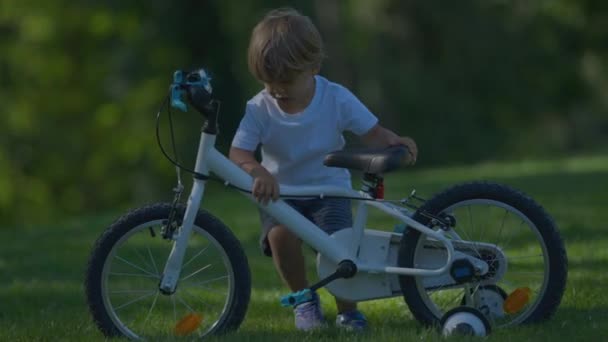 抱着被卡住的自行车的孩子不能把自行车抬上山坡 — 图库视频影像