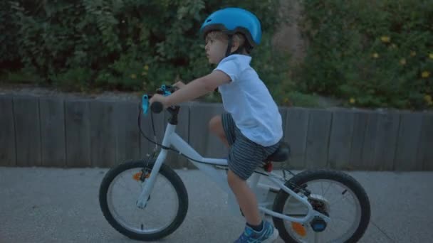 孩子们戴着防护头盔在外面骑自行车 — 图库视频影像