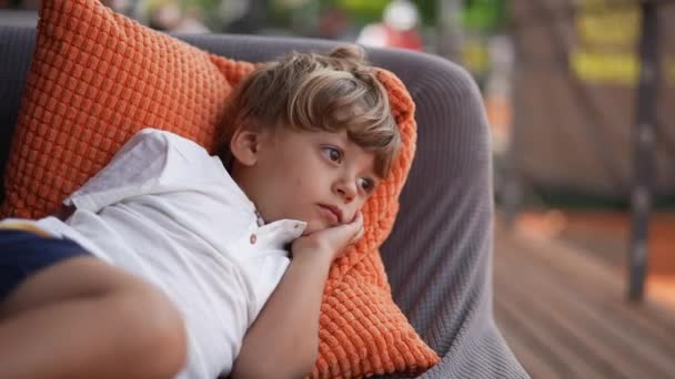 Προσεκτικό Αγοράκι Που Ξαπλώνει Στον Καναπέ Και Σκέφτεται Στοχαστικό Παιδί — Αρχείο Βίντεο