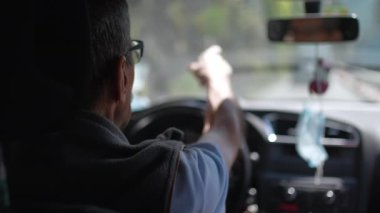 Yaşlı bir adam yolda araba kullanıyor. Yaşlı bir şoför yolda.