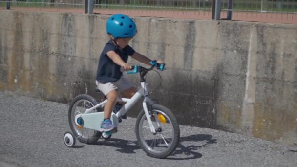 一个孩子在城外的人行道上骑自行车 — 图库视频影像