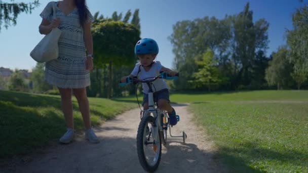 夏の日の間 公園の外で母親と一緒に自転車に乗る小さな男の子 — ストック動画