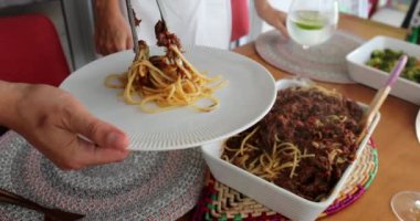 Yemekte spagetti servis eden yakın el.
