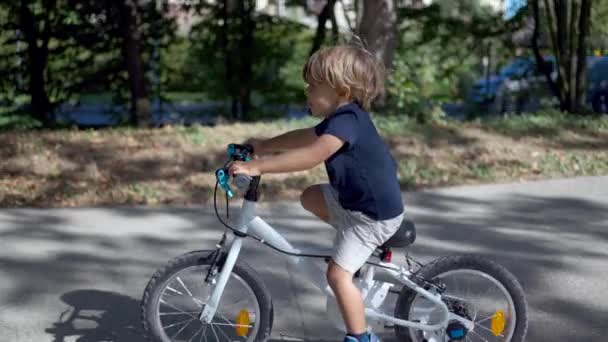 小男孩骑自行车在外面的阳光下 — 图库视频影像