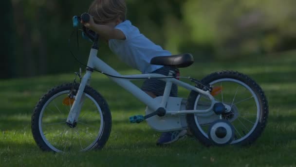 小さな男の子の外に自転車を運ぶ子供はヘルメットを着て自転車を運ぶ — ストック動画