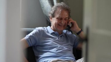 Son sınıf öğrencisi koltukta oturmuş telefonla konuşuyor.