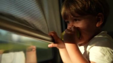 Çocuk altın saatinde trene biniyor zaman çocuğu trenle seyahat ediyor.