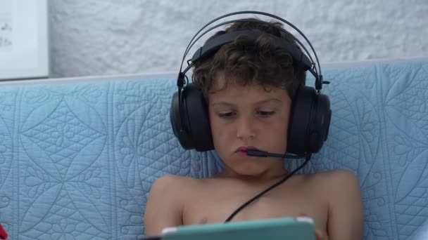 Niño Jugando Juego Dispositivo Tableta Casa Con Auriculares Con Micrófono — Vídeos de Stock