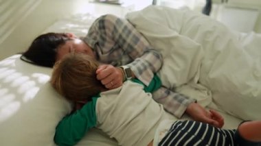 Child and mother affection cuddle in bed together