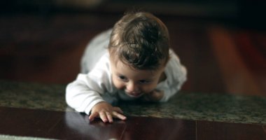 Cute baby development learning crawl on home floor. Adorable infant one year old portrait