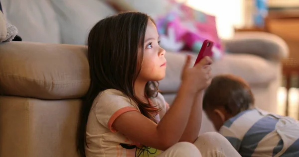 Casual Little Girl Watching Screen Holding Smartphone Device Night — Foto de Stock