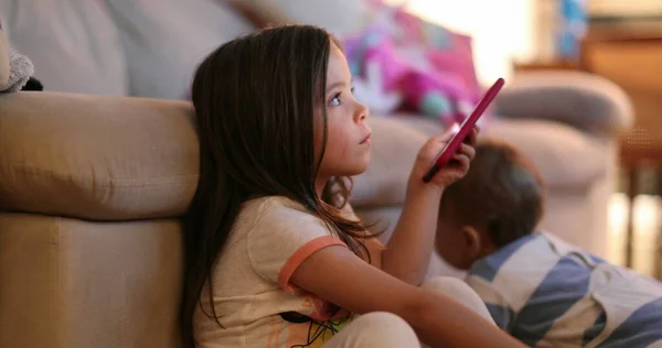 Casual Little Girl Watching Screen Holding Smartphone Device Night — Zdjęcie stockowe