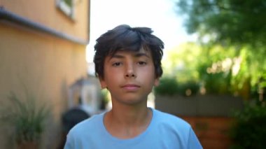 Mutlu genç çocuk gülümseyen bir portre yüzüyle yürüyor