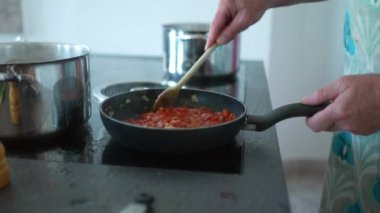 İnsanlar evde yemek pişiriyor, samimi büyükbaba ve yetişkin kız mutfakta yemek hazırlıyorlar.