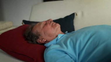 Yaşlı adam kanepede dinleniyor. Son sınıf öğrencisi uyuyor.