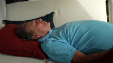 Yaşlı adam kanepede dinleniyor. Son sınıf öğrencisi uyuyor.