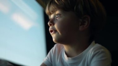 Küçük çocuk pencereden dışarı bakarak trenle seyahat ediyor.