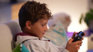 Küçük çocuk taşınabilir konsol üzerinde video oyunu oynuyor Çocuk oyun oynuyor