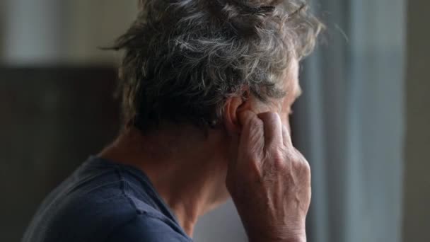 Older Man Touching Ear Scratching Earlobe Standing Window — Stockvideo